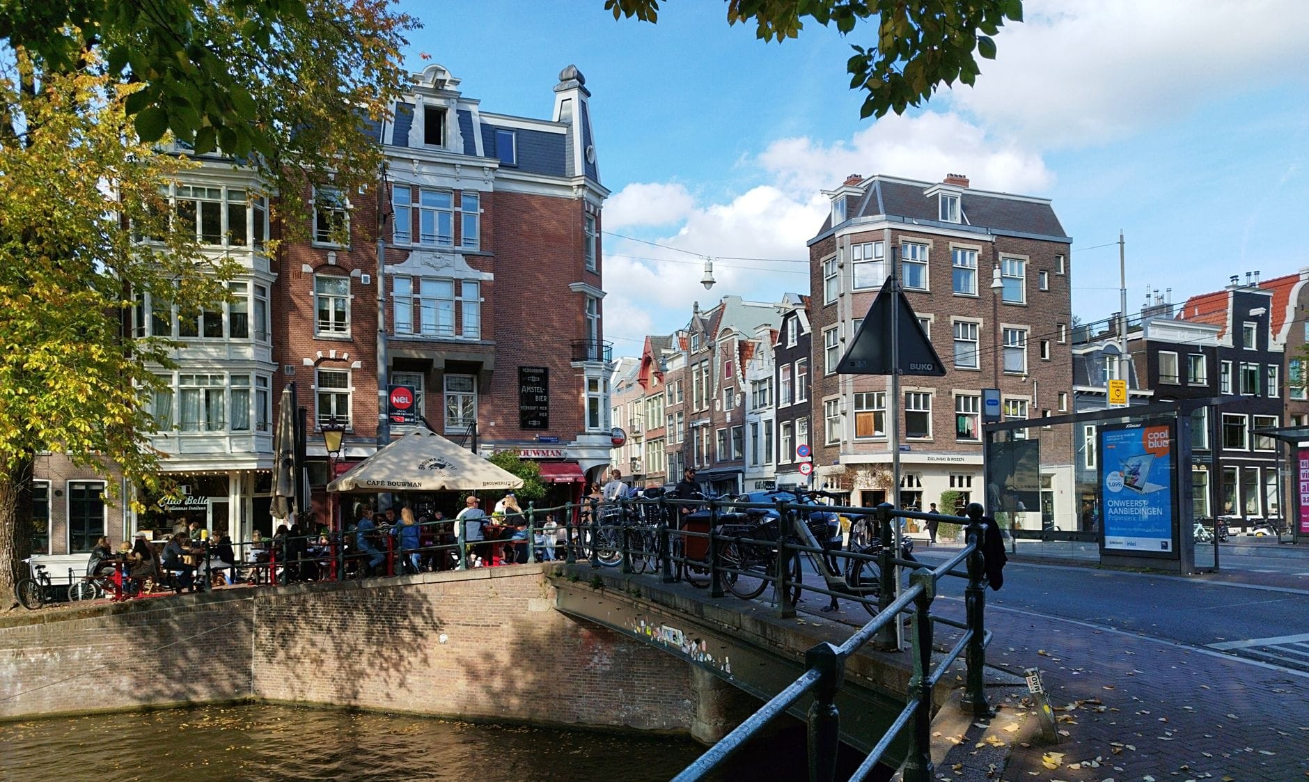 Holenderskie kawiarnie bruin café: gdzie poczuć lokalny klimat miasta Rowerowa uliczka nad kanałem w Amsterdamie z historycznymi kamienicami