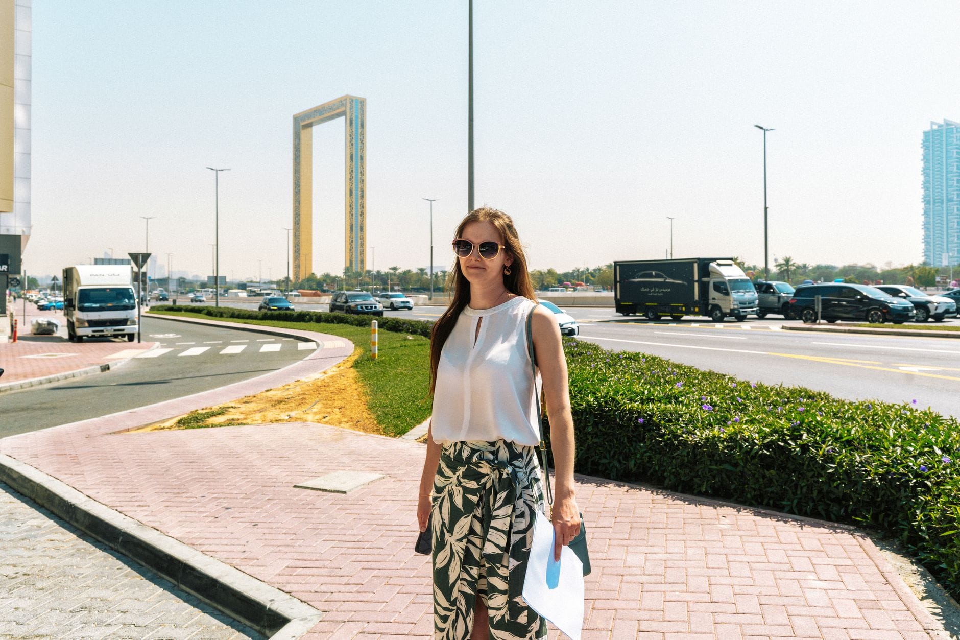 Kobieta spaceruje w słońcu obok Dubai Frame w Dubaju