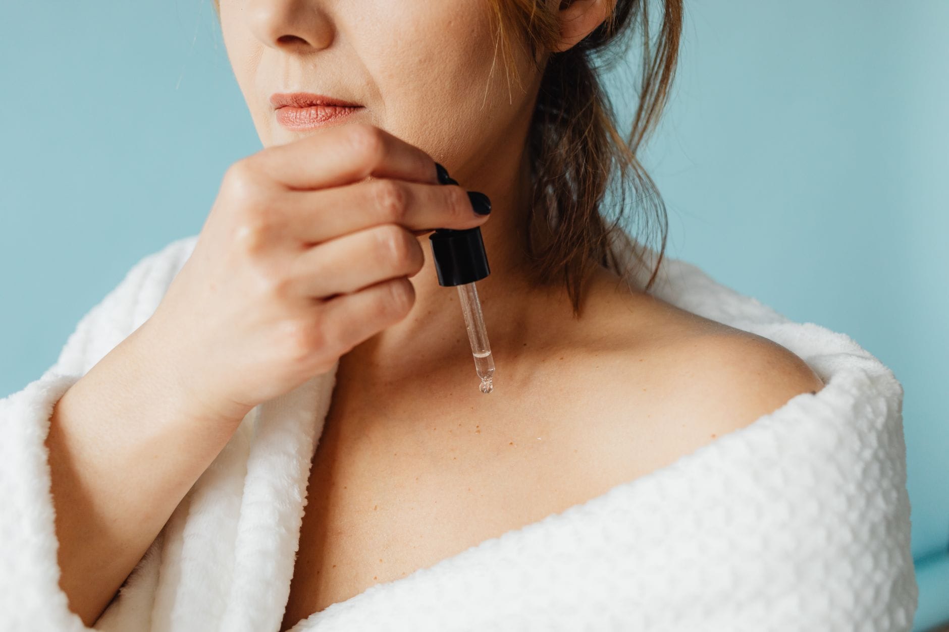 Jak dobrać serum do twarzy krok po kroku – przewodnik po składnikach dla każdego typu cery Kobieta w szlafroku nakłada serum na twarz podczas pielęgnacji