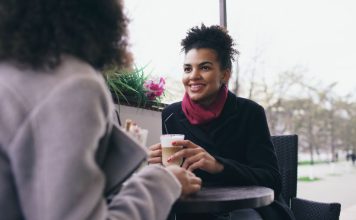 Jak poznawać Brazylijczyków: niewypowiedziane zasady gościnności, dystansu i small talku Dwie kobiety rozmawiają przy kawie w ogródku kawiarnianym w Brazylii